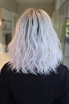 A woman with shoulder-length wavy pink wig (Somers by Estetica in Polarizing Pink).