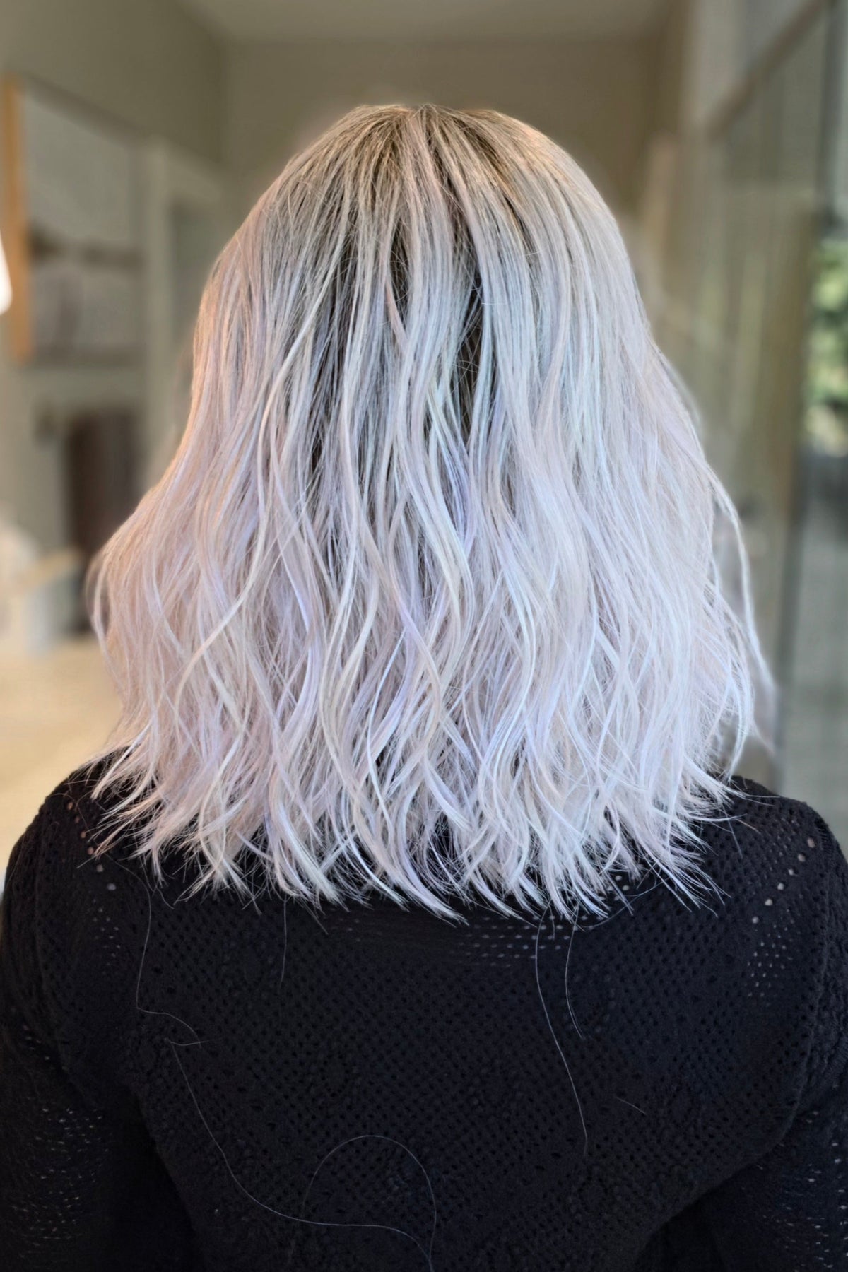 A woman with shoulder-length wavy pink wig (Somers by Estetica in Polarizing Pink).