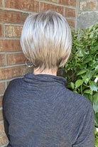 A smiling woman with short silver-gray wig (Vesper by Estetica in color R51LF60)