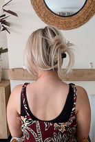 Woman wearing straight layered blonde wig (Evangeline by PUSH Hair in color Pearl Silk).