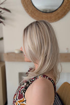 Woman wearing straight layered blonde wig (Evangeline by PUSH Hair in color Pearl Silk).