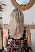 Woman wearing straight layered blonde wig (Evangeline by PUSH Hair in color Pearl Silk).
