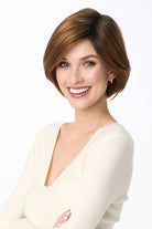 Woman wearing a sleek brown synthetic bob wig by Envy with a natural lace front and monofilament part.