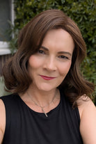 Woman wearing curled bob wig (Exhilaration by Gabor in Light Brown)