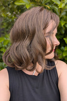 Woman wearing curled bob wig (Exhilaration by Gabor in Light Brown)