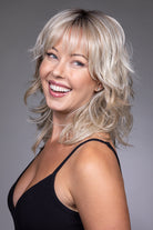Woman wearing a blonde, textured shag wig with wispy bangs and a natural lace front monofilament top.