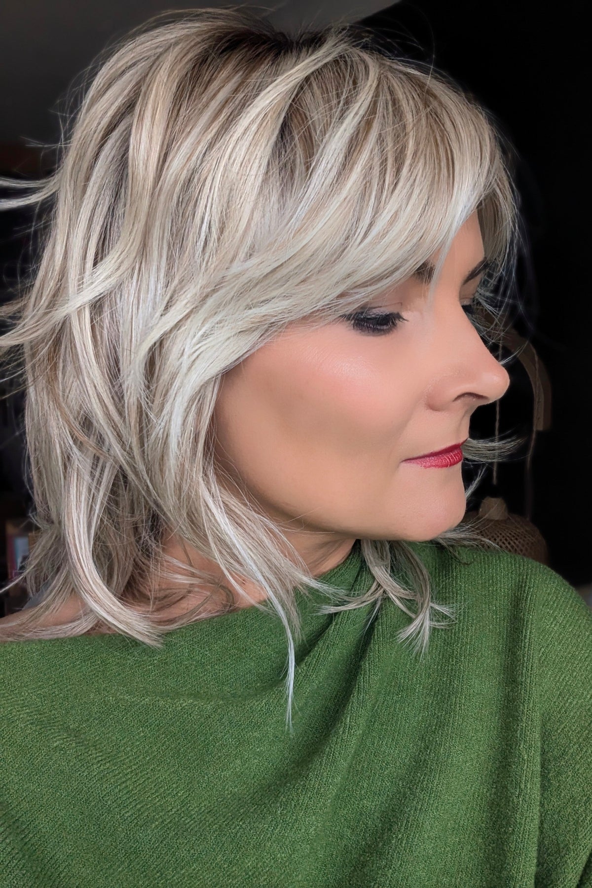 A woman with short blonde layered wig (Farrah by Belle Tress in color Butterbeer-R)
