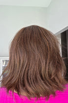 Woman wearing shoulder length wavy bob (Farren by Amore in Ginger Brown).
