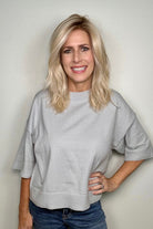 Woman wearing long layered wavy rooted blonde wig (Fenix by Estetica in Sunlit Blonde)