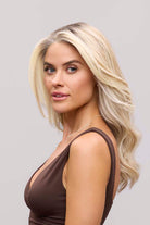 Fiona Lite heat-friendly synthetic wig in blonde with long, flowing waves and a natural lace front hairline.