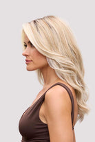 Fiona Lite heat-friendly synthetic wig in blonde with long, flowing waves and a natural lace front hairline.