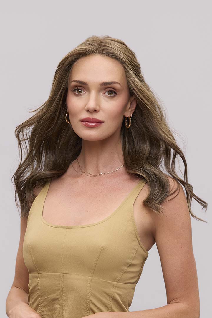 Fiona Lite heat-friendly synthetic wig featuring long, wavy brown layers and a natural lace front hairline.