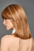 Shoulder-length synthetic bob wig in a warm auburn blend with face-framing curtain bangs and tapered layers.