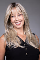 Gigi by Belle Tress long blonde layered synthetic wig with curtain bangs and a natural lace front.