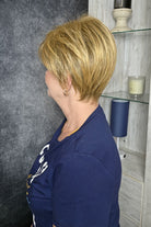 Woman wearing short pixie wig (Friendship by Gabor in color Dark Blonde). 