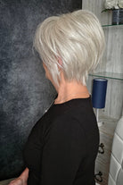 Woman with chin-length blonde bob wig (Wonderful Wit by Gabor in Light Gray).