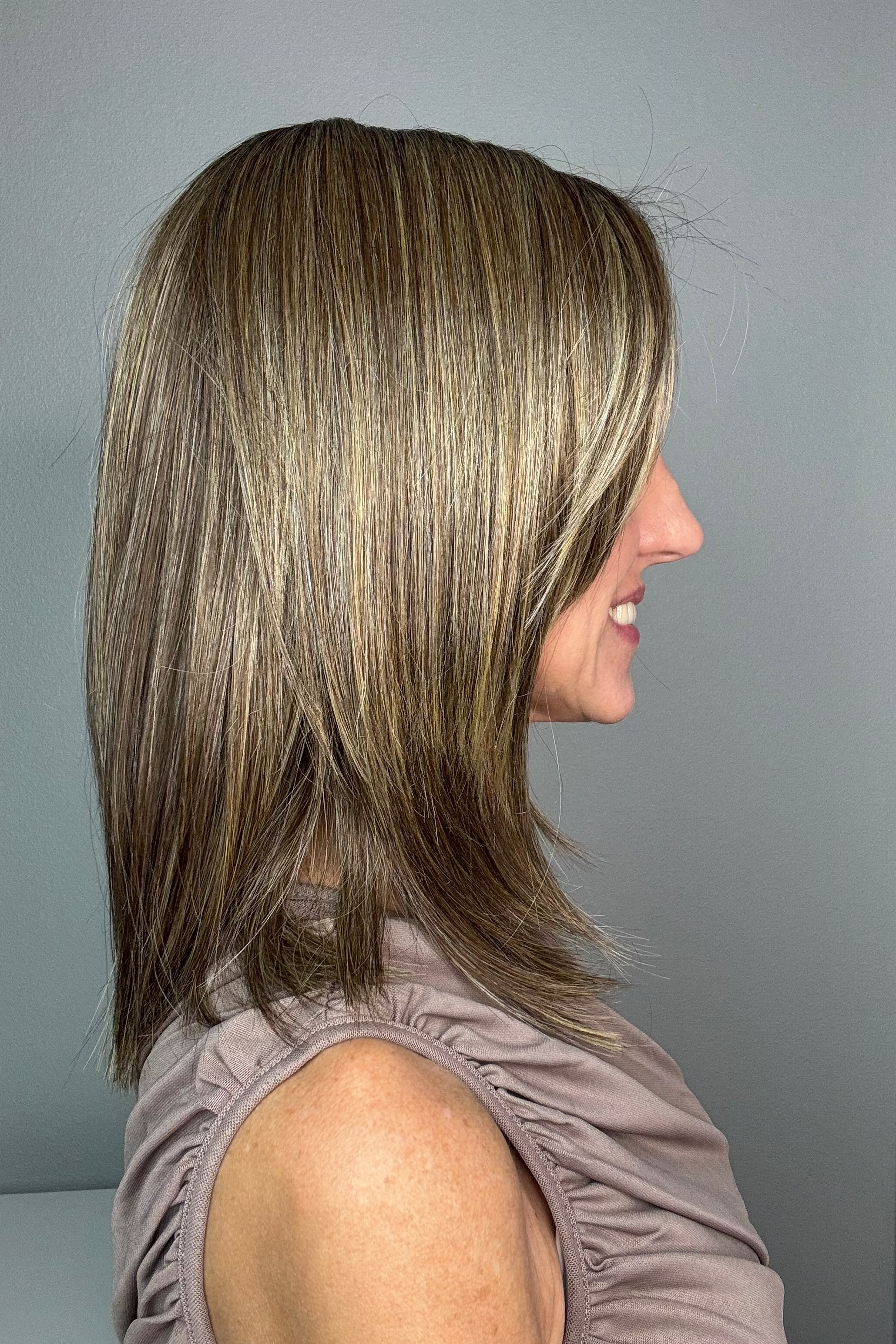 Woman wearing shoulder-length straight wig (Serving Looks by Gabor in color Iced Cafe Latte).