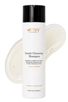 A bottle of Envy by Hair Gentle Cleansing Shampoo with a black cap and white bottle, shown in front of a translucent smear of the shampoo on a white background.