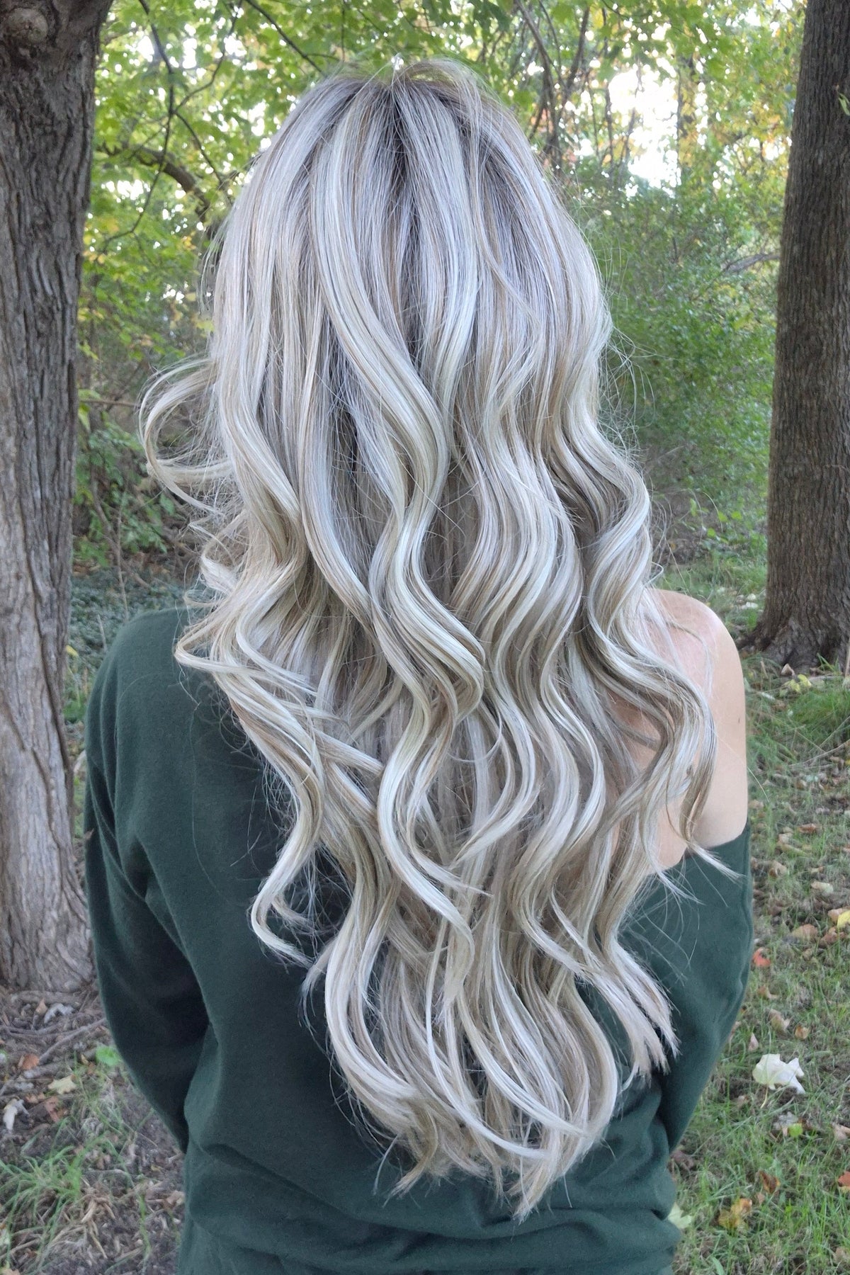 A woman with long blonde wavy wig (Gisele by Belle Tress in color Butterbeer R). 