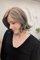 Woman with short, styled brunette wig (Harper by WigPro in Camel Brown) side