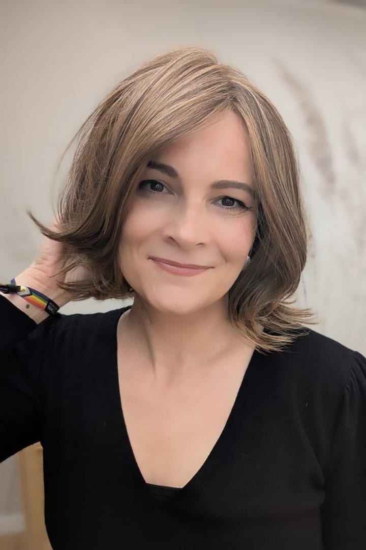 Woman with short, styled brunette wig (Harper by WigPro in Camel Brown)