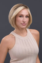 Woman in a beige top wearing Ignite Petite Remy Human Hair Lace Front Wig in a blonde bob style.