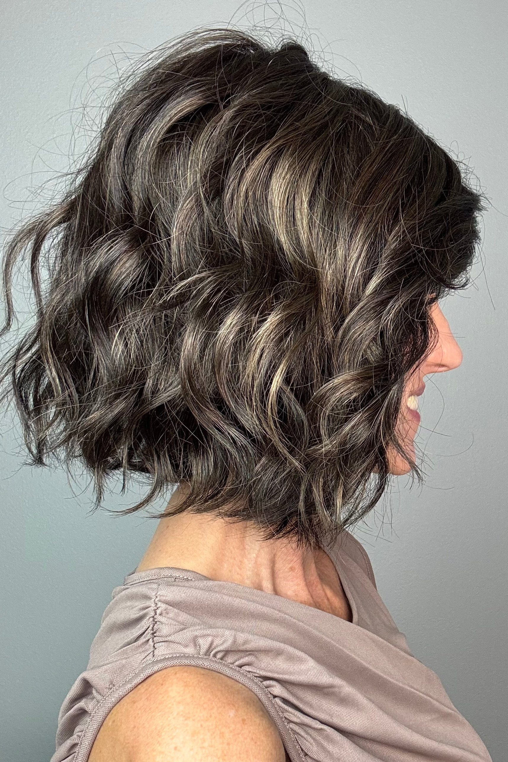 A smiling woman with short dark brown wig (January by Jon Renau in color Mocha Latte R)