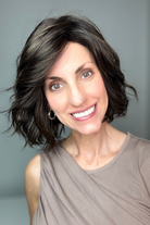 A smiling woman with short dark brown wig (January by Jon Renau in color Mocha Latte R)