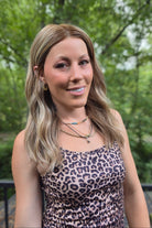 A woman with blonde wavy hair wearing a leopard print dress (Morgan by Jon Renau in Malibu Blonde)