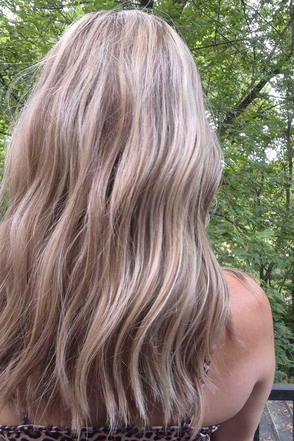 A woman with blonde wavy hair wearing a leopard print dress (Morgan by Jon Renau in Malibu Blonde)