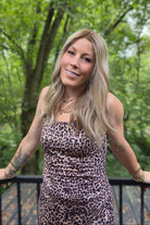 A woman with blonde wavy hair wearing a leopard print dress (Morgan by Jon Renau in Malibu Blonde)
