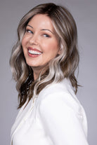Magnolia by Belle Tress shoulder-length wavy synthetic wig with money piece highlights and a center part.