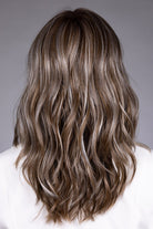 Back view of Magnolia heat-friendly synthetic wig with shoulder-length, layered, wavy brown hair and blonde highlights.