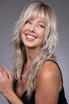 Muse by Belle Tress long blonde shag wig with wispy bangs, feathered layers, and a natural lace front.