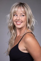 Muse by Belle Tress long blonde shag wig with wispy bangs, textured layers, and a natural lace front hairline.