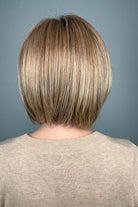 Woman wearing blonde bob with bangs (Meadow by Henry Margu in 12/26GR).