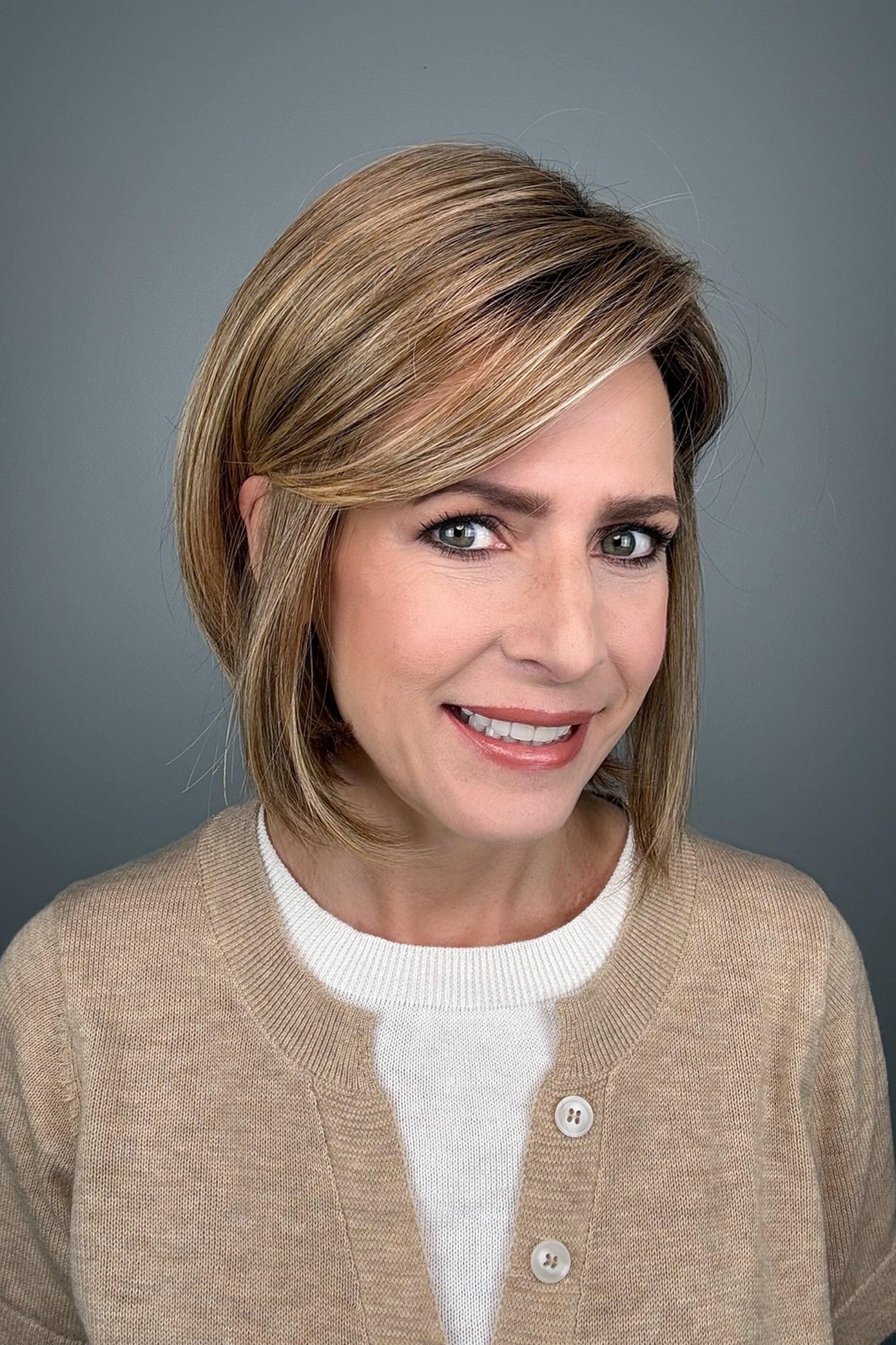 Woman wearing blonde bob with bangs (Meadow by Henry Margu in 12/26GR).