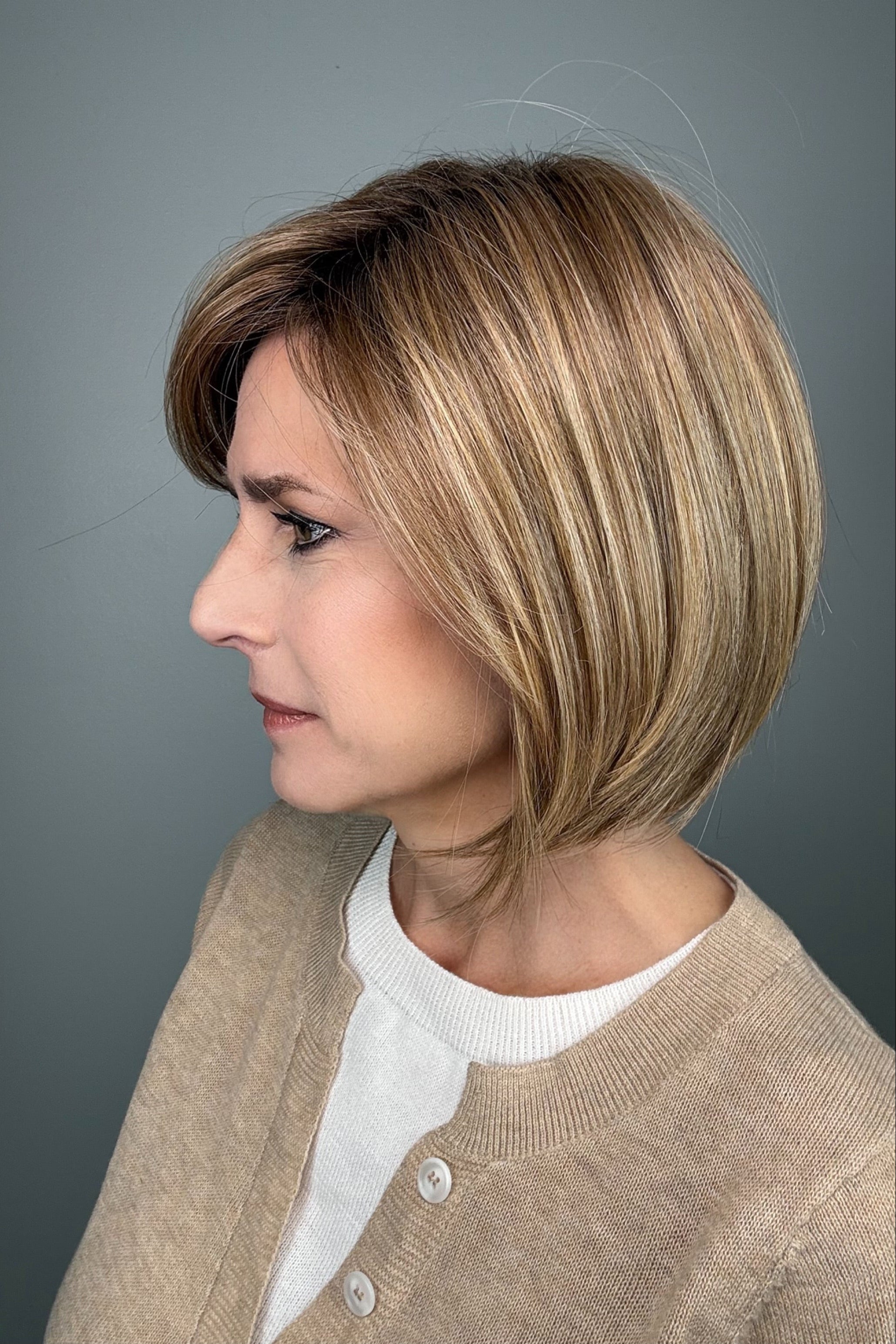 Woman wearing blonde bob with bangs (Meadow by Henry Margu in 12/26GR).