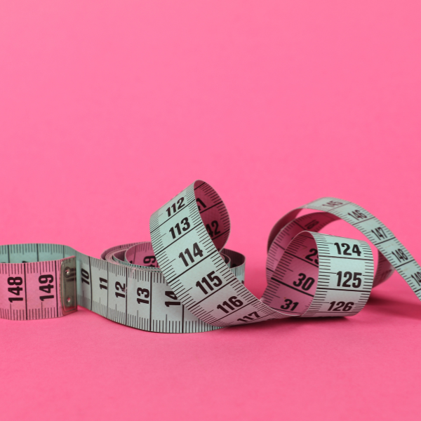 Measuring tape on a pink background