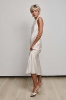 Mio by Noriko short blonde layered pixie wig with lace front and mono part on a woman in a cream satin dress.