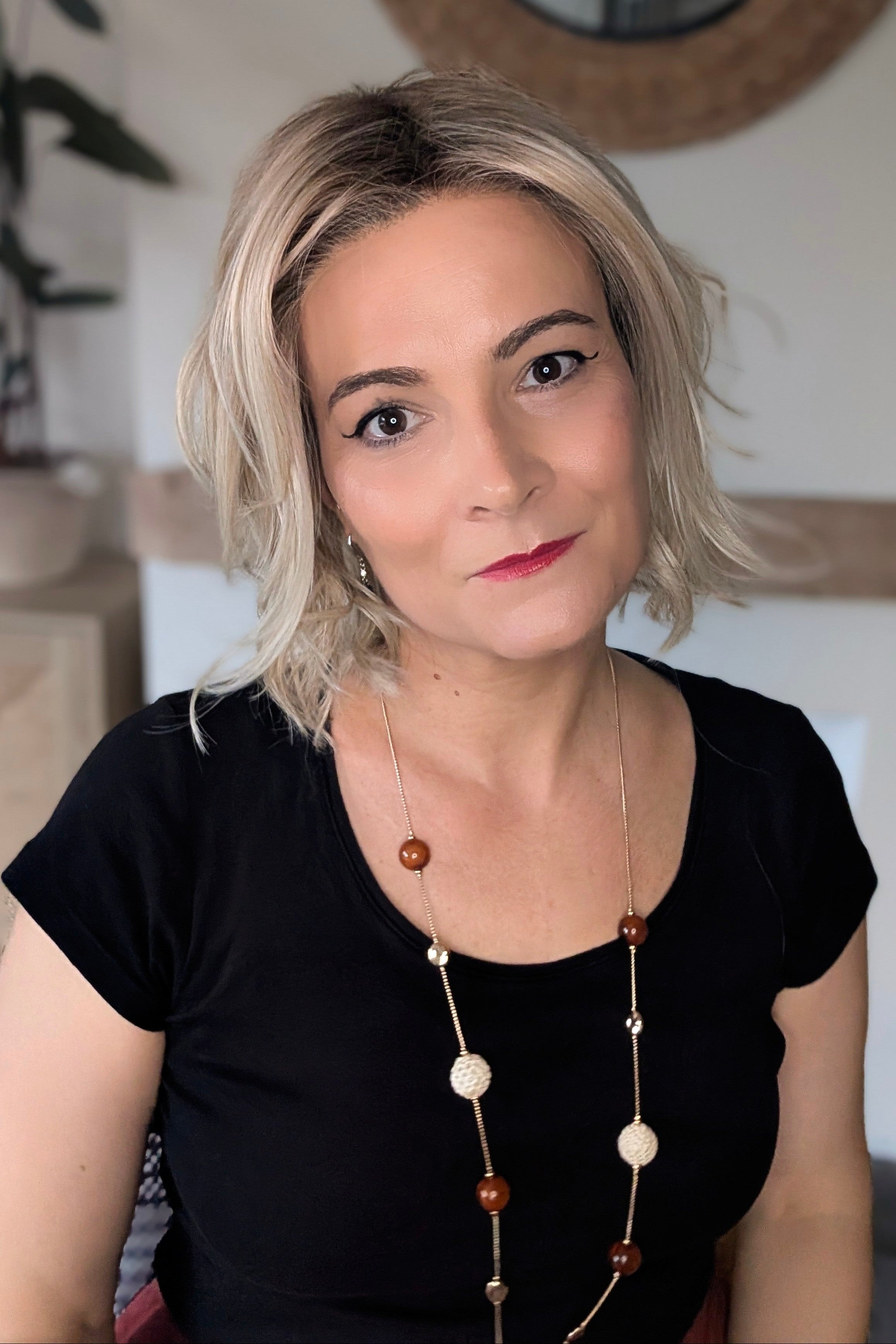 A woman with short blonde wavy bob wig (Naples by Belle Tress in color Crushed Almond Blonde R).
