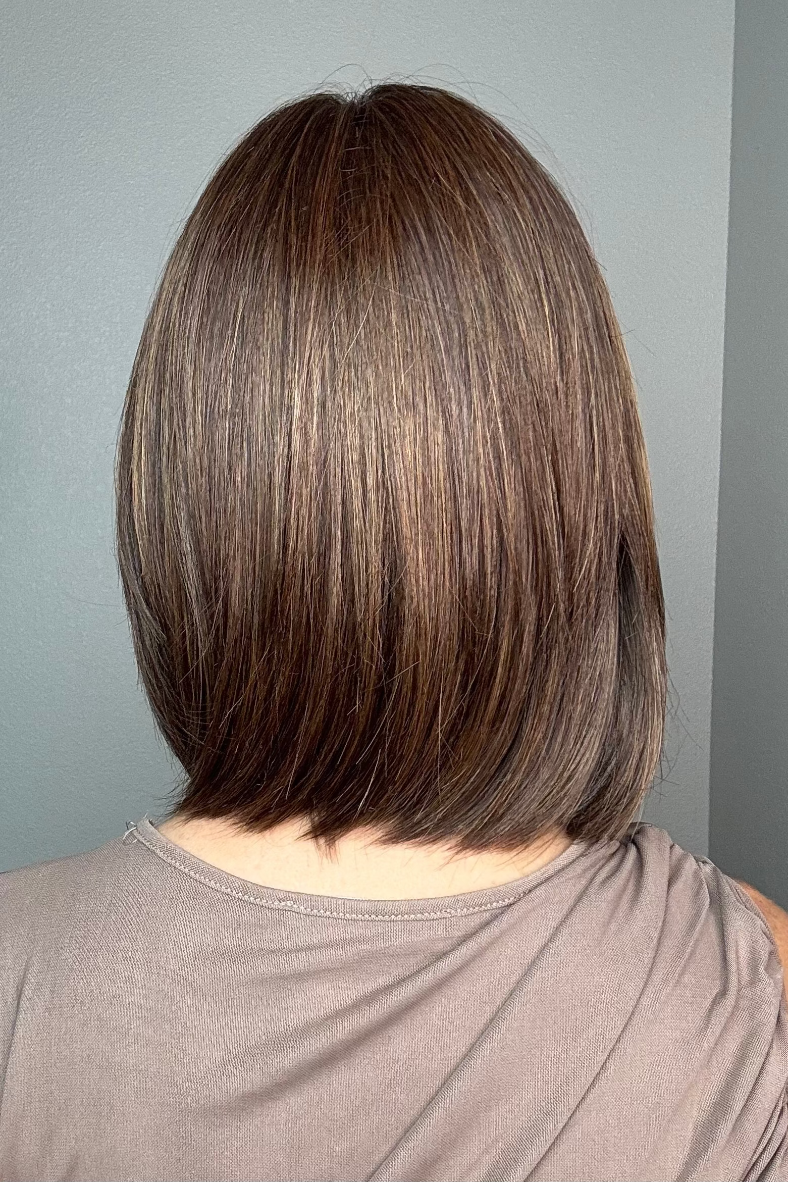 A woman with a shoulder-length brown bob haircut and straight bangs (Ami by Noriko in color Marble Brown-R)