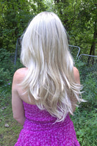 A woman with long blonde layered wig (Angelica by Noriko in Champagne R).