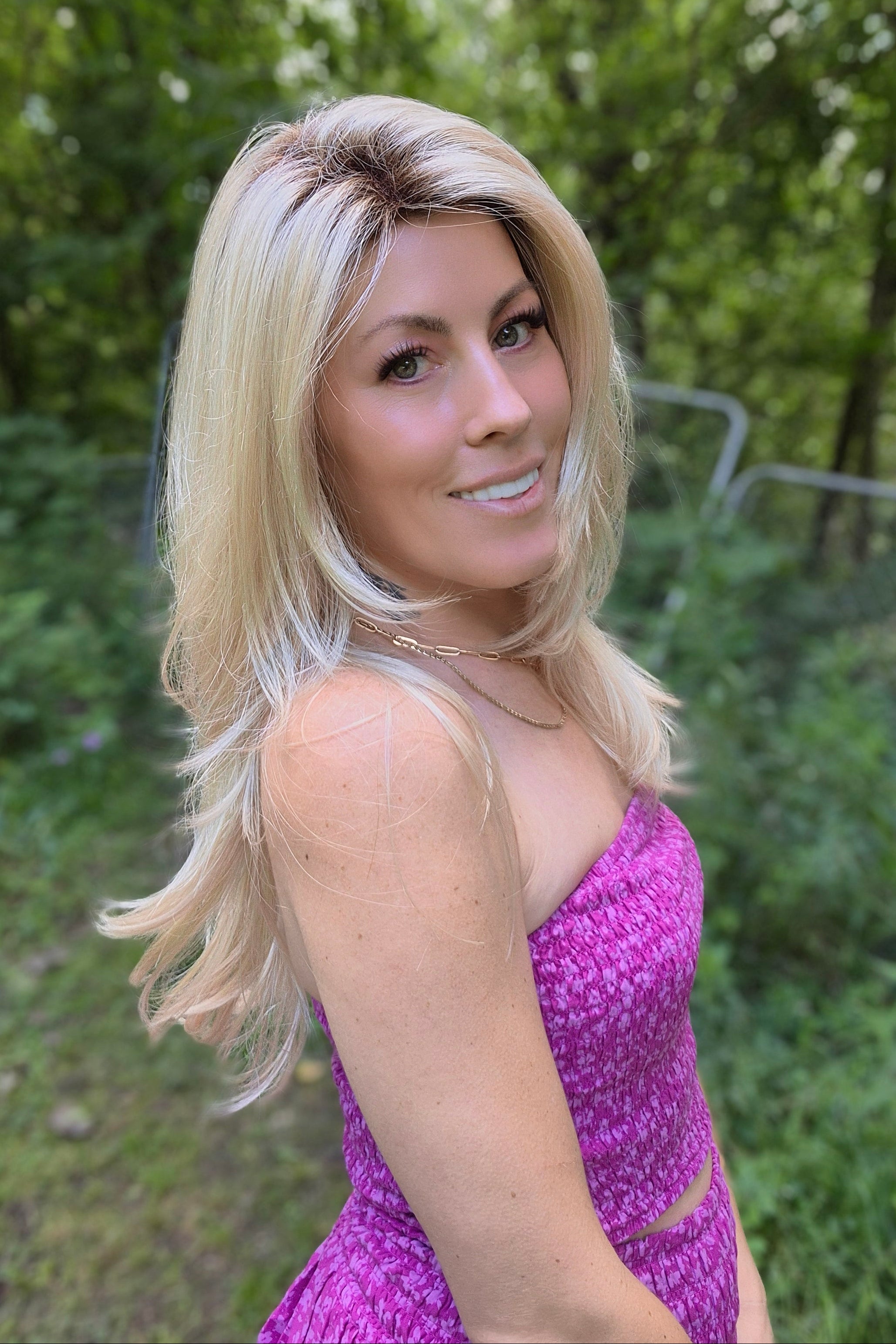 A woman with long blonde layered wig (Angelica by Noriko in Champagne R).