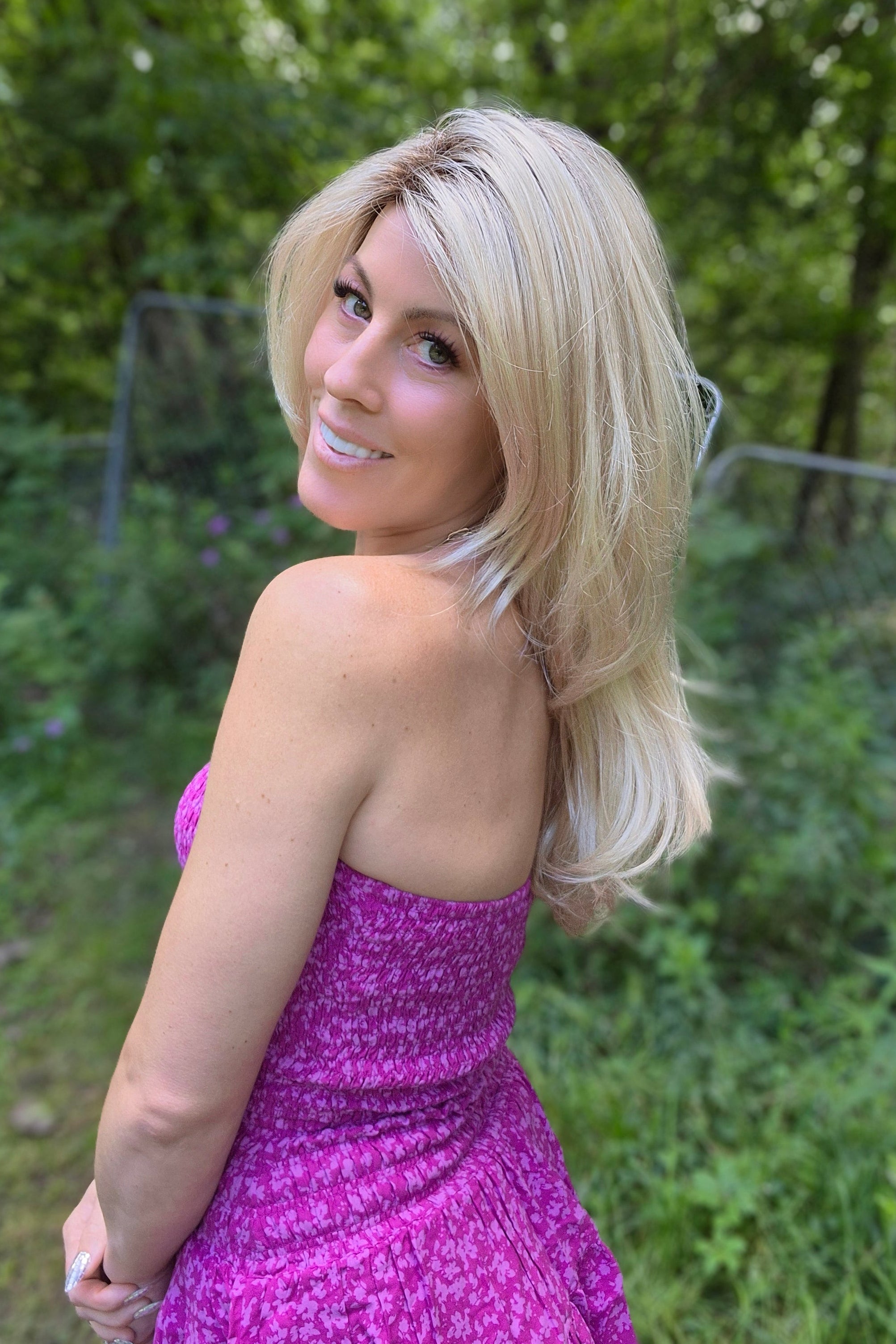 A woman with long blonde layered wig (Angelica by Noriko in Champagne R).