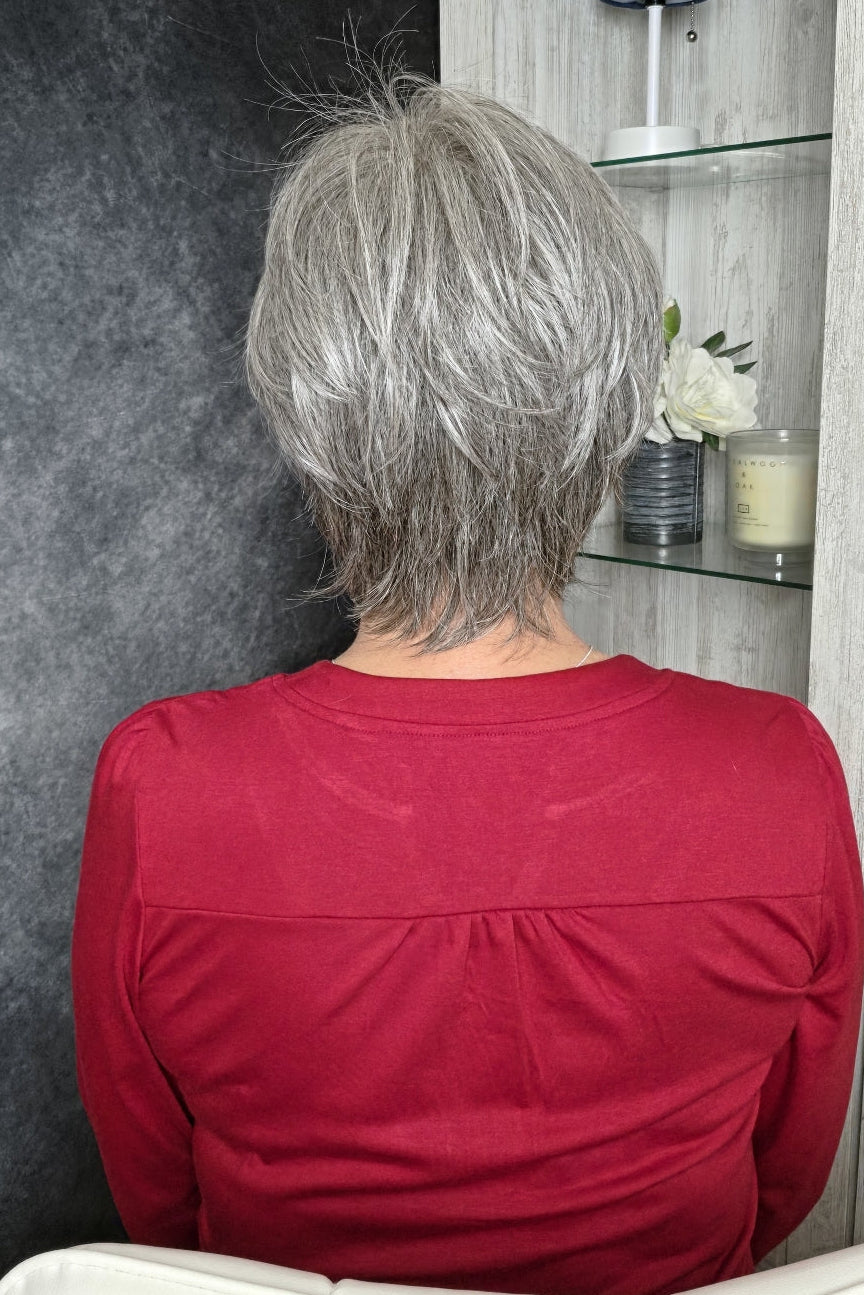 A woman with short gray bixie wig (Mio by Noriko in color Silverstone).