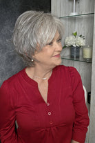 A woman with short gray bixie wig (Mio by Noriko in color Silverstone).