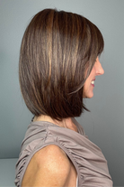 A woman with a shoulder-length brown bob haircut and straight bangs (Ami by Noriko in color Marble Brown-R)