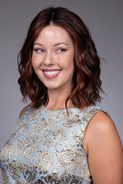 Orchid by Belle Tress shoulder-length wavy bob wig with a center part and auburn money piece highlights.