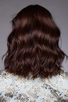 Back view of a shoulder-length, wavy auburn bob wig with textured layers and heat-friendly synthetic fiber.